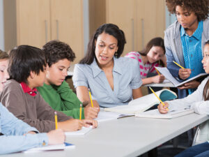 Multi-ethnic group of students with teacher in classroom.